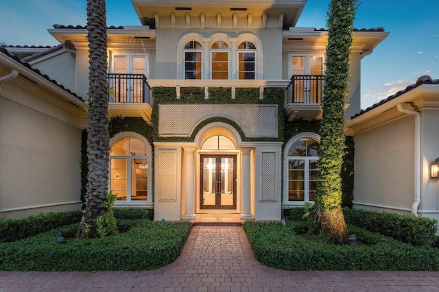 view of front of property featuring french doors and a balcony