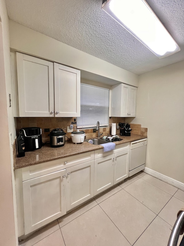 kitchen featuring a textured ceiling, dishwasher, white cabinetry, sink, and light tile patterned floors