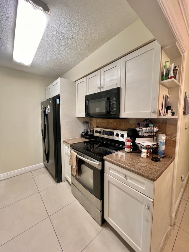 kitchen with black appliances, light tile patterned flooring, white cabinetry, a textured ceiling, and dark stone counters