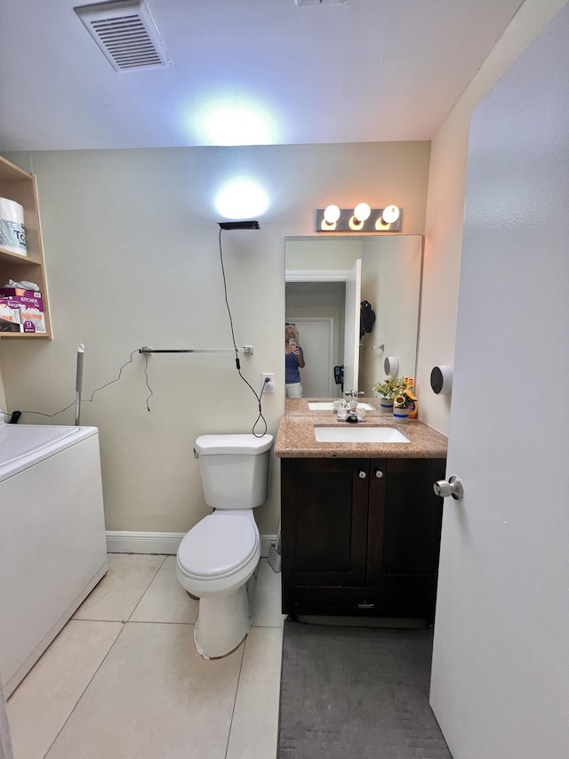 bathroom featuring toilet, washer / clothes dryer, tile patterned flooring, and vanity