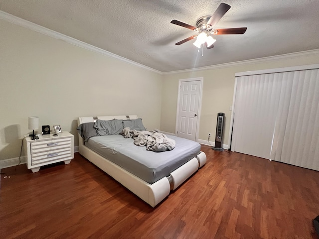 bedroom with a textured ceiling, ceiling fan, dark hardwood / wood-style flooring, and crown molding