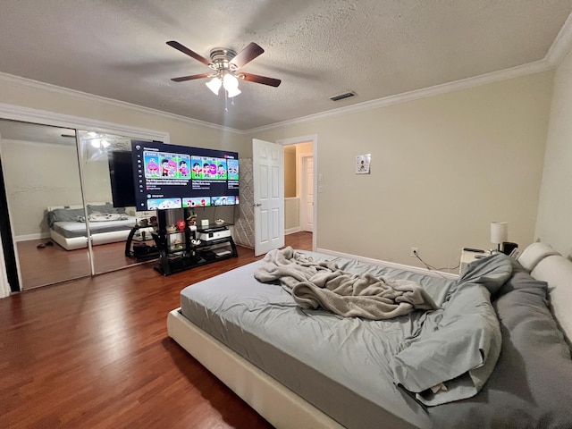 bedroom featuring ceiling fan, hardwood / wood-style flooring, a closet, and ornamental molding