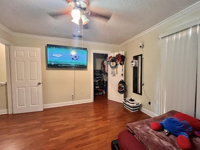 bedroom with ceiling fan, dark wood-type flooring, crown molding, and a textured ceiling