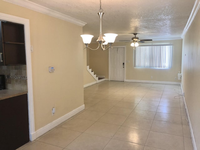 spare room featuring light tile patterned flooring, ceiling fan with notable chandelier, a textured ceiling, and ornamental molding