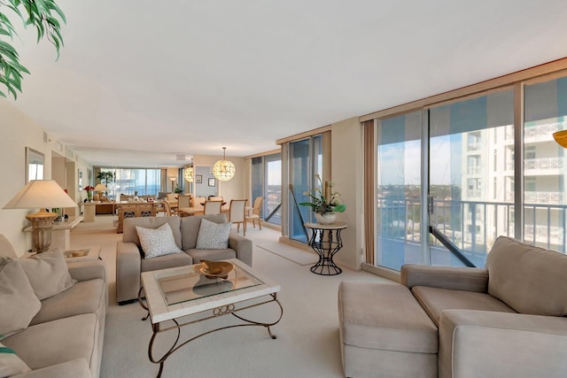 living room with an inviting chandelier, light colored carpet, and expansive windows