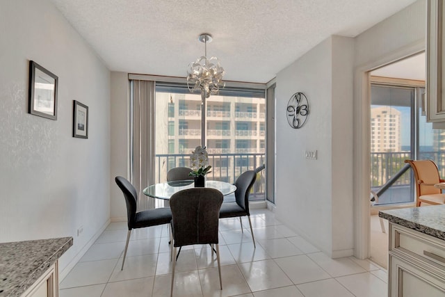 dining area with a textured ceiling, floor to ceiling windows, a chandelier, and light tile patterned flooring