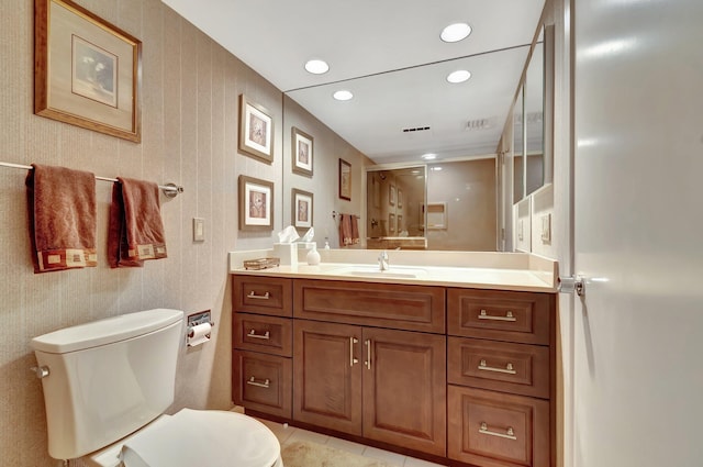 bathroom featuring walk in shower, vanity, toilet, and tile patterned flooring