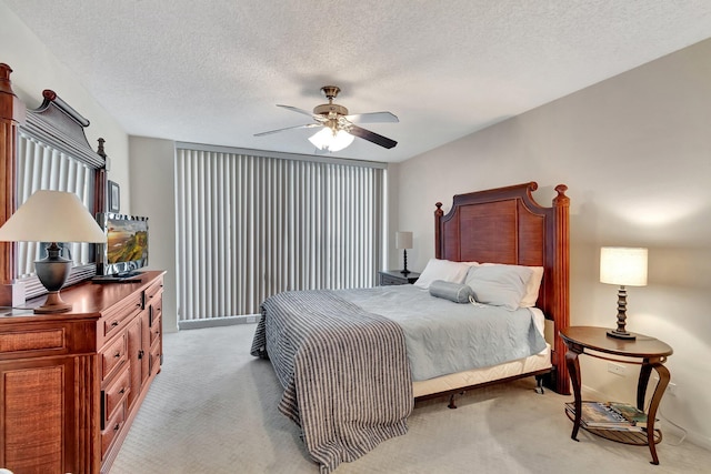 carpeted bedroom with ceiling fan and a textured ceiling