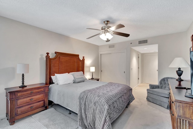 carpeted bedroom featuring ceiling fan and a textured ceiling