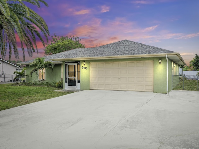 ranch-style house with a garage and a lawn