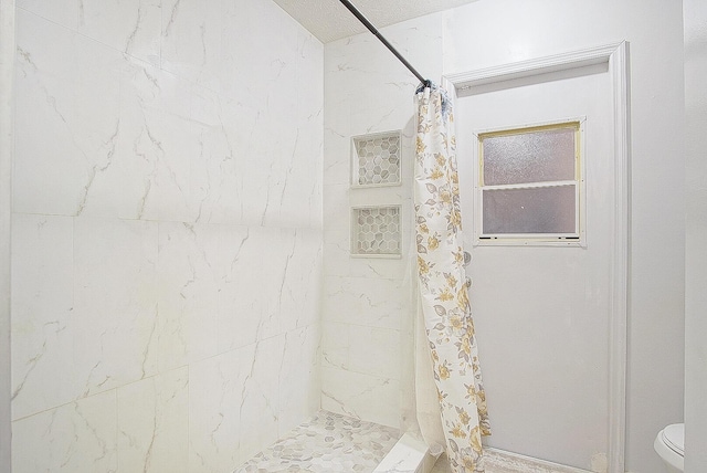 bathroom featuring curtained shower and toilet