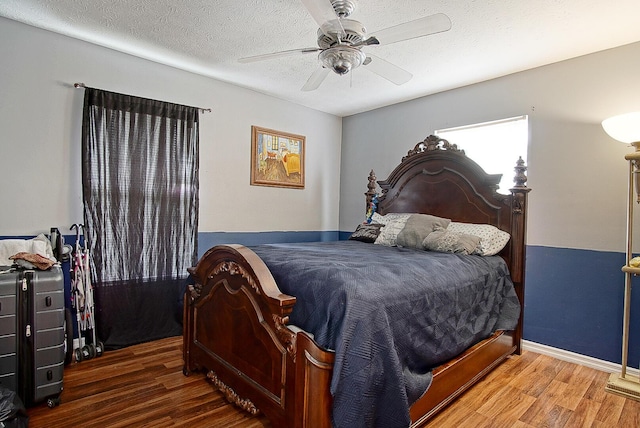 bedroom featuring a textured ceiling, ceiling fan, and dark hardwood / wood-style flooring