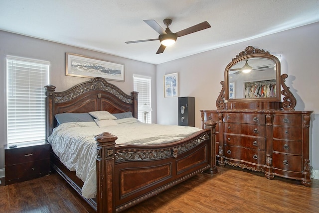 bedroom with ceiling fan, multiple windows, and dark hardwood / wood-style flooring