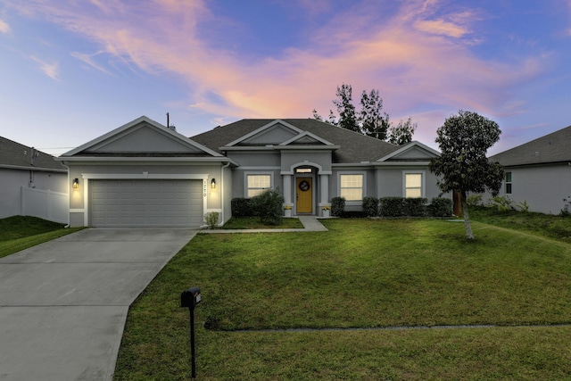 single story home featuring a lawn and a garage