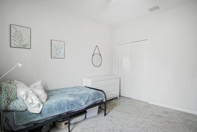 bedroom featuring ceiling fan, light carpet, and a closet