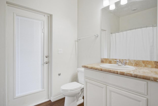 bathroom with vanity, hardwood / wood-style flooring, and toilet