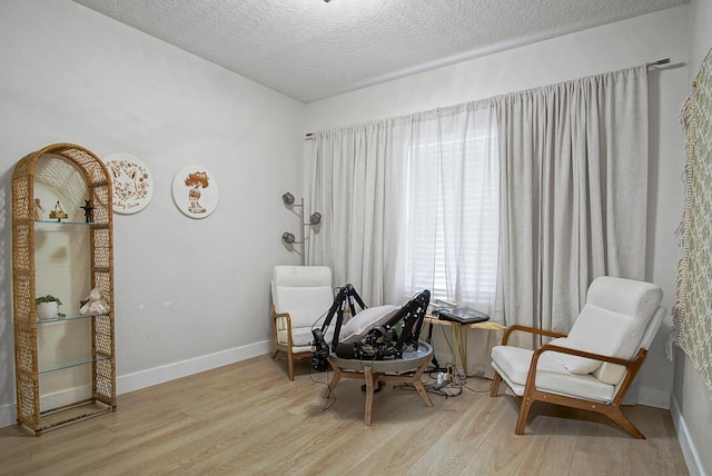 living area featuring a textured ceiling and light hardwood / wood-style flooring