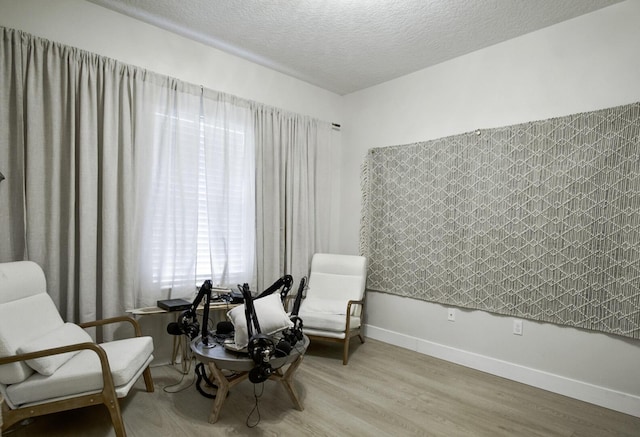 sitting room with light hardwood / wood-style floors and a textured ceiling