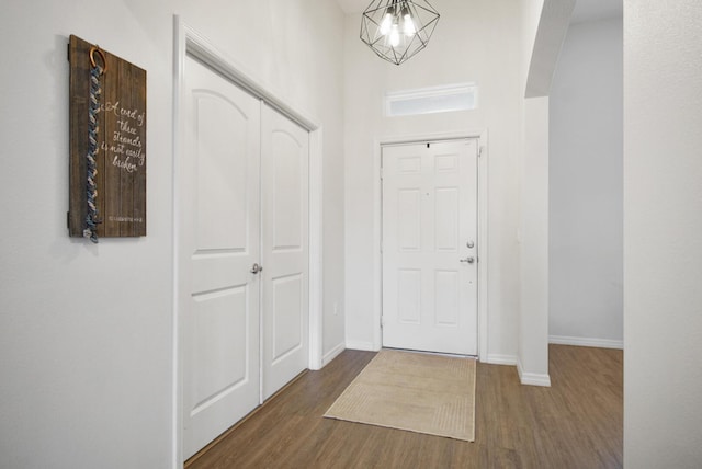 entryway with hardwood / wood-style flooring and a chandelier