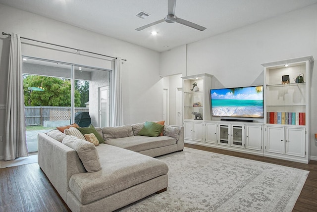 living room featuring a ceiling fan, visible vents, and dark wood finished floors