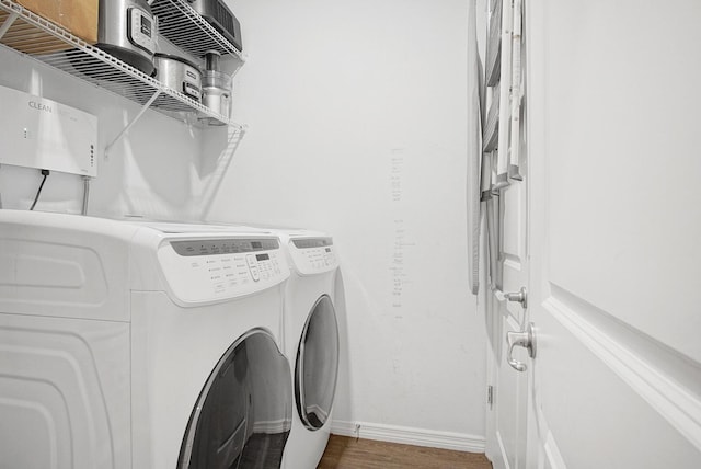 clothes washing area featuring wood-type flooring and washer and dryer