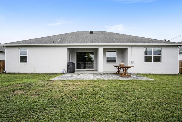 rear view of property with a patio and a lawn