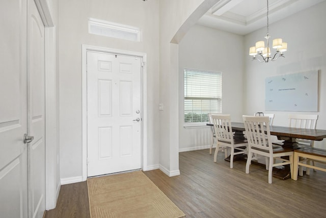 dining area with wood-type flooring, a chandelier, and a high ceiling