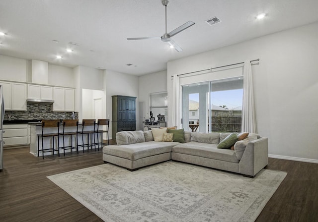 living room featuring ceiling fan and dark hardwood / wood-style floors