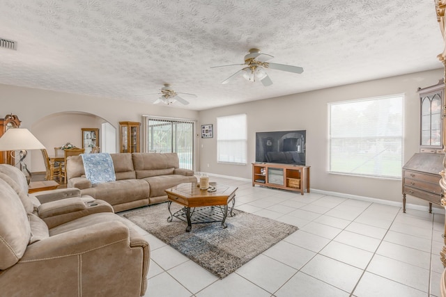 living room with ceiling fan, a textured ceiling, and light tile patterned floors