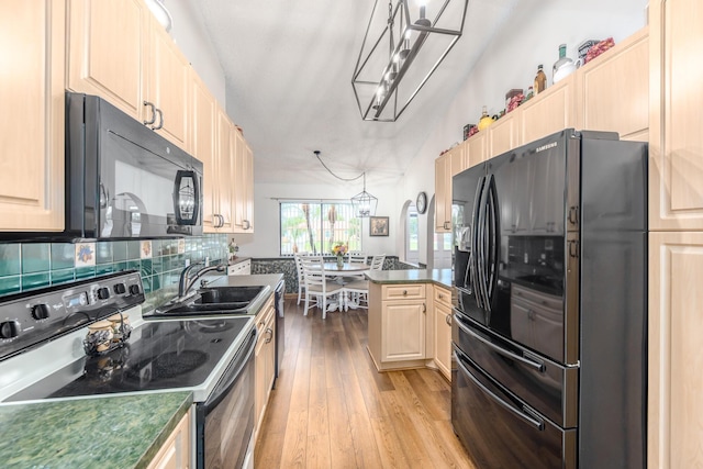 kitchen with black appliances, decorative light fixtures, sink, backsplash, and light wood-type flooring