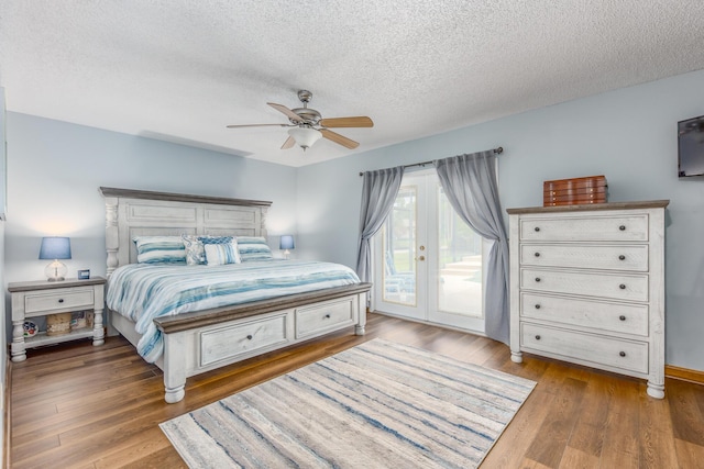 bedroom featuring ceiling fan, access to exterior, a textured ceiling, and hardwood / wood-style floors