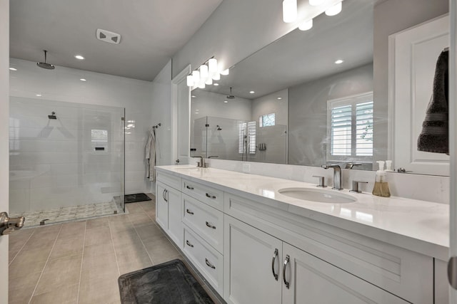 bathroom with tile patterned flooring, walk in shower, and vanity