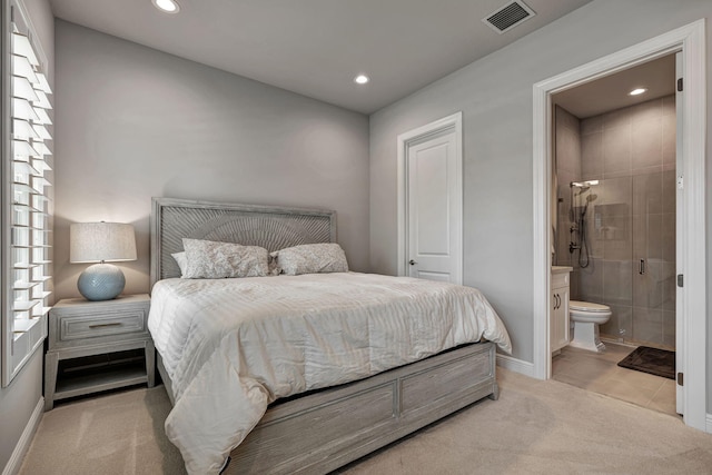 bedroom featuring light colored carpet and ensuite bath