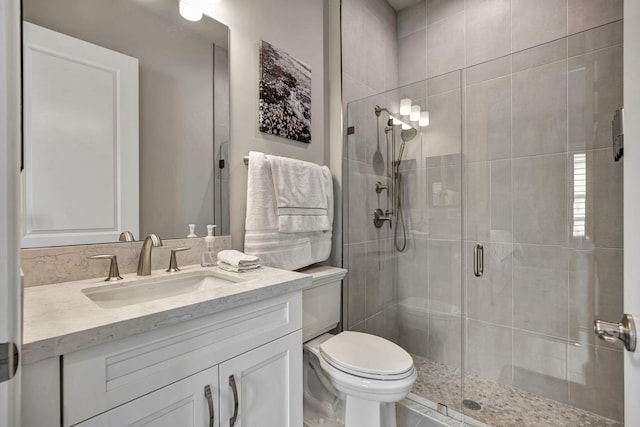 bathroom with walk in shower, vanity, and toilet