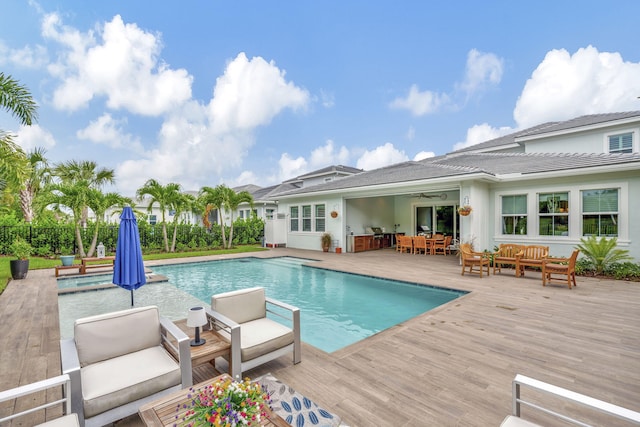 view of pool featuring ceiling fan, outdoor lounge area, and a deck