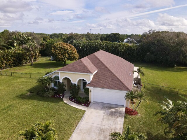 mediterranean / spanish-style house featuring a garage and a front lawn