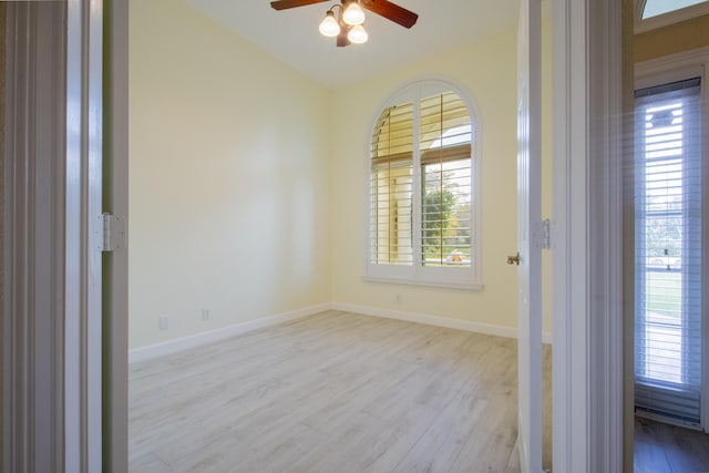 empty room featuring lofted ceiling, ceiling fan, baseboards, and wood finished floors