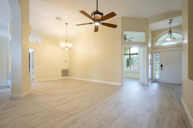 foyer entrance with high vaulted ceiling, light wood finished floors, and visible vents