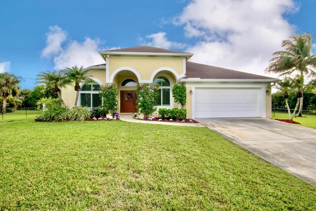 mediterranean / spanish house featuring a garage and a front yard