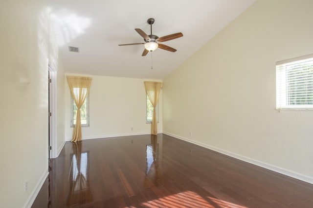 unfurnished room featuring a wealth of natural light, vaulted ceiling, baseboards, and wood finished floors