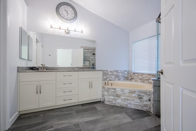 full bath featuring lofted ceiling, a stall shower, a sink, and a garden tub