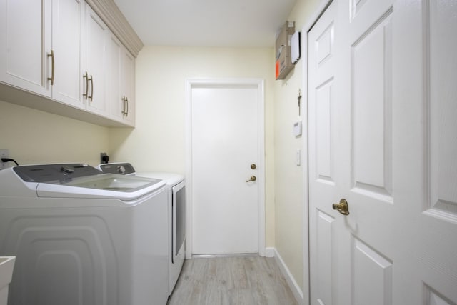 laundry area featuring light wood-type flooring, cabinet space, independent washer and dryer, and baseboards