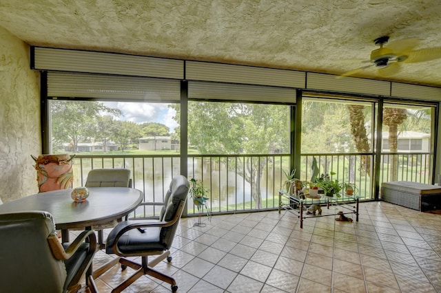 sunroom with a water view and ceiling fan