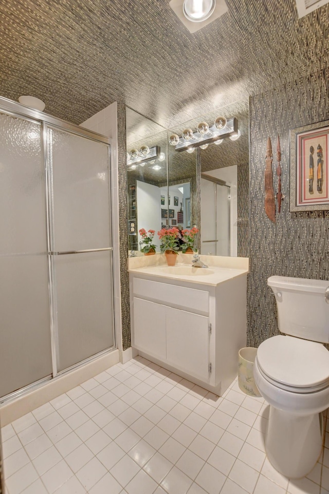 bathroom with a shower with shower door, tile patterned floors, vanity, and toilet