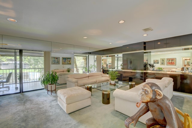 living room with floor to ceiling windows, light colored carpet, and a healthy amount of sunlight