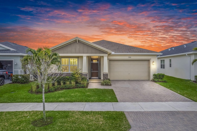 view of front of home with a garage and a lawn