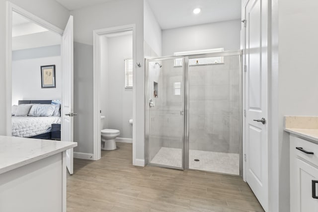 bathroom featuring vanity, toilet, and a shower with shower door