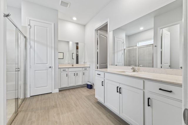 bathroom featuring vanity, wood-type flooring, and walk in shower