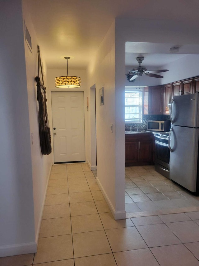 hall featuring sink and light tile patterned floors