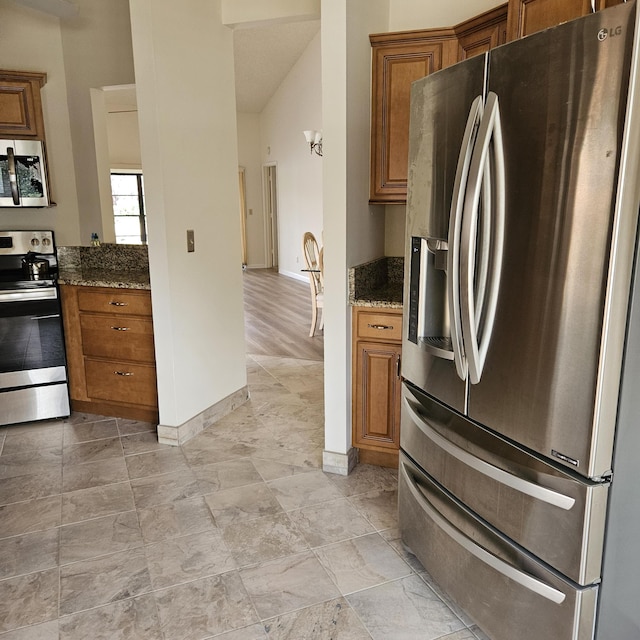 kitchen featuring appliances with stainless steel finishes and dark stone countertops